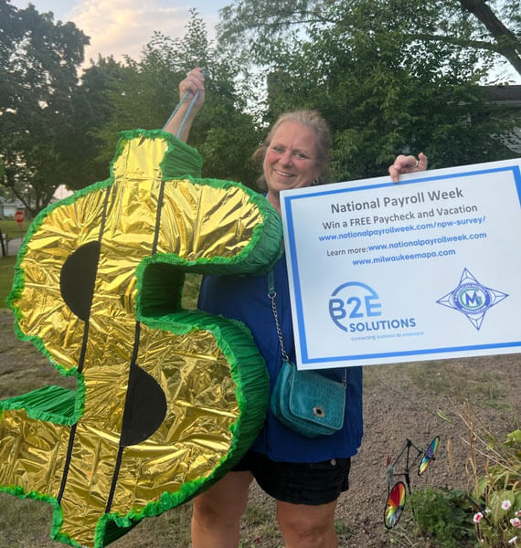 NPW Survey winner smiling holding up dollar sign prop